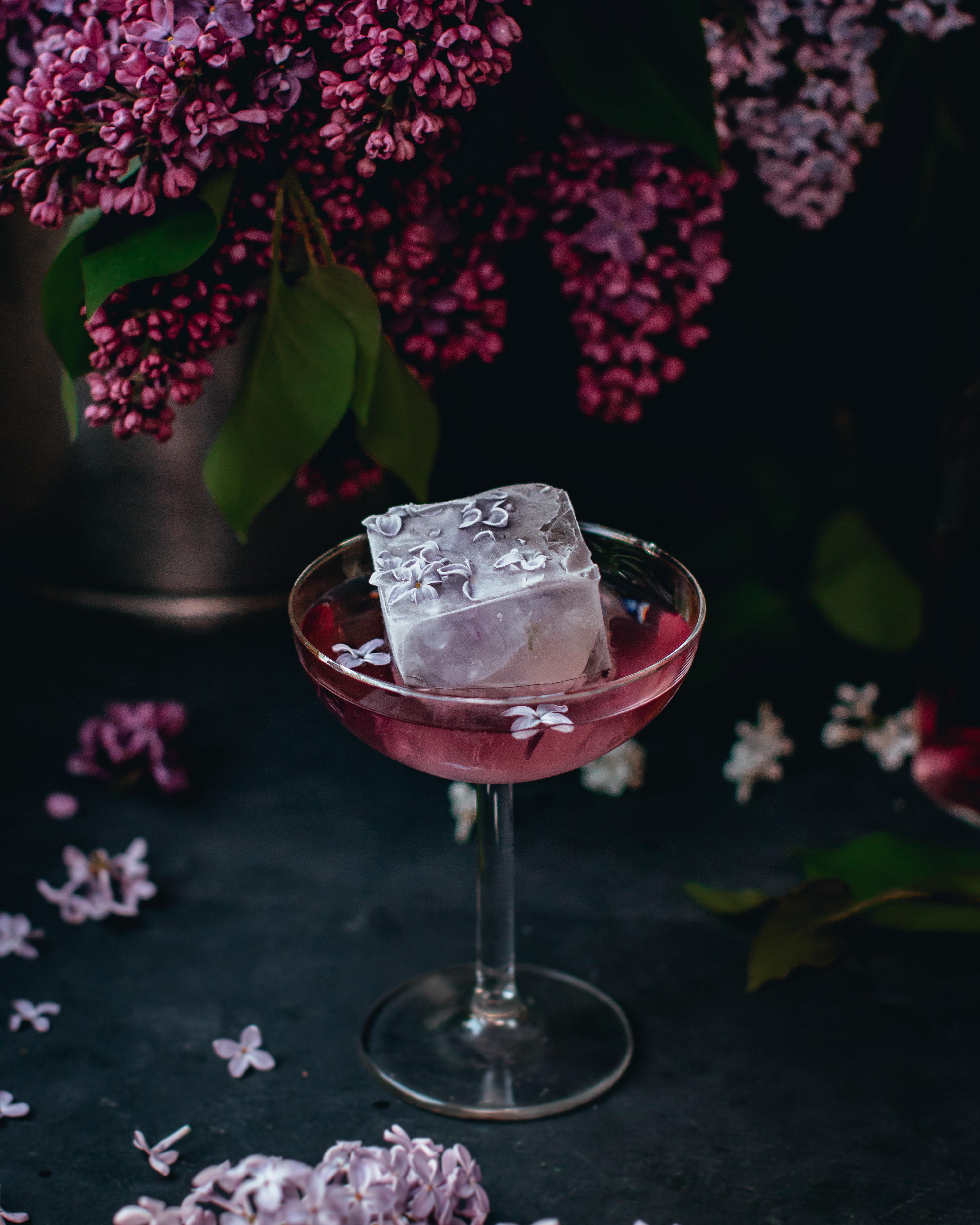 A lilac drink beside flowers